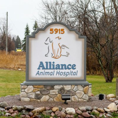 Outside sign for Alliance Animal Hospital. Logo is the outline of a dog on left, a cat in the middle and a rabbit on the right